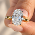 Front close-up of a 4 carat oval lab grown diamond engagement ring with pavé band in yellow gold