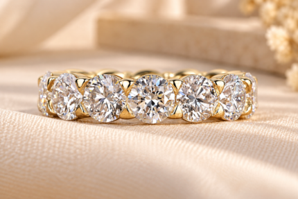 Close-up of round lab diamond eternity setting on cream fabric