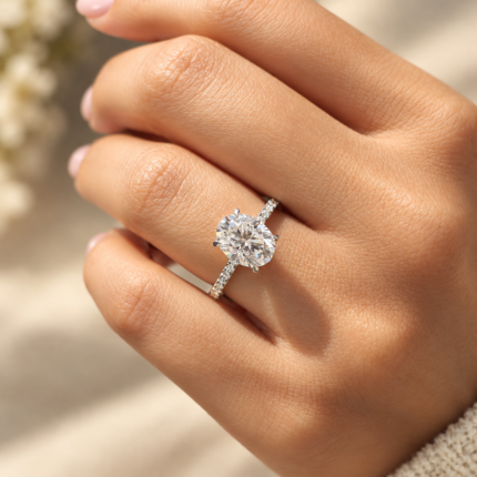 Angled view of oval moissanite pavé ring on a relaxed hand