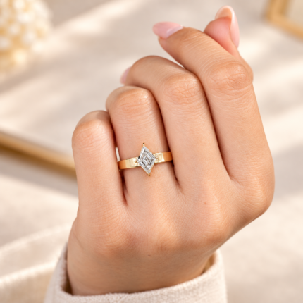 Lozenge lab grown diamond ring on a hand with neutral nails, showing the tapered cigar band