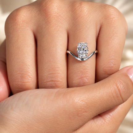 Oval lab diamond curved solitaire ring on a hand for scale