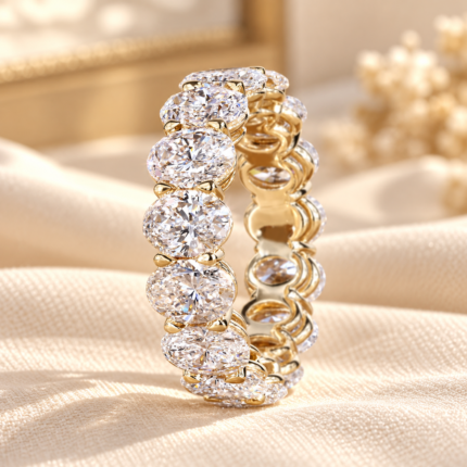 Oval shared prong band with a continuous row of oval diamonds and a gold tone basket gallery, angled view