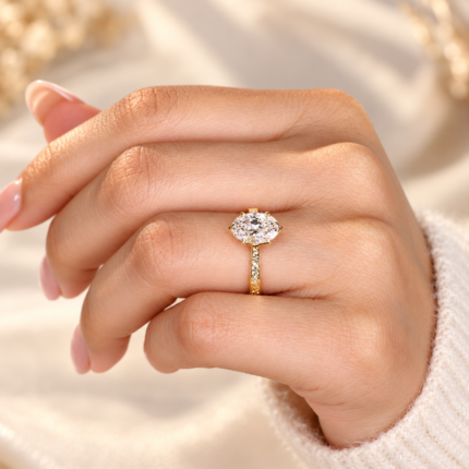 Top hand close-up of oval lab diamond and engraved band