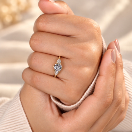 Round lab diamond trilogy ring on a loosely closed hand