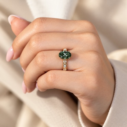 Green oval vintage ring, on a curled hand