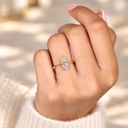 Dutch marquise diamond engagement ring on a hand beside a knit cuff