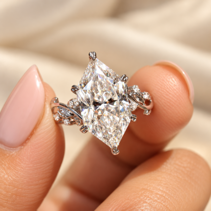 Dutch marquise moissanite ring held between fingers, showing leaf prongs and side accents