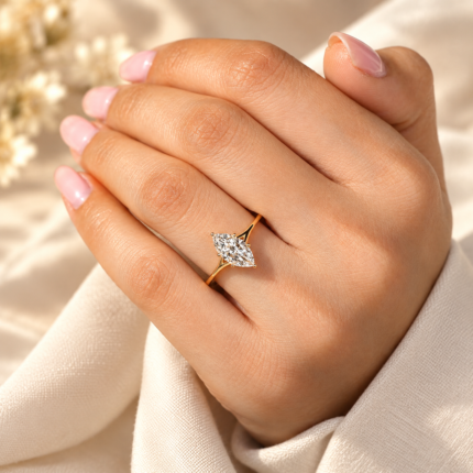 Split shank marquise solitaire ring worn on a relaxed hand, showing the elongated diamond center