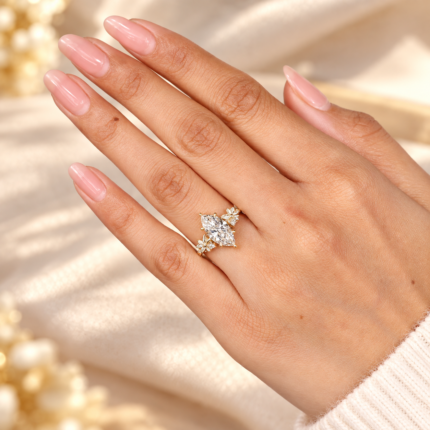 Marquise lab diamond floral engagement ring, worn on a hand with neutral manicure