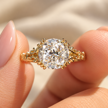 Portuguese cut moissanite solitaire held between fingers, showing ornate fishtail prongs