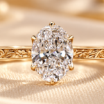 Flower engraved oval ring with a lab grown diamond and floral yellow gold tone shank, front view