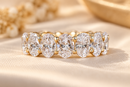 Front close-up of the oval shared prong band showing the continuous oval diamond row