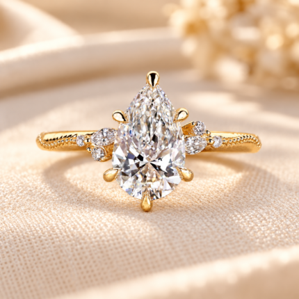 Vintage pear engagement ring, front view on cream fabric