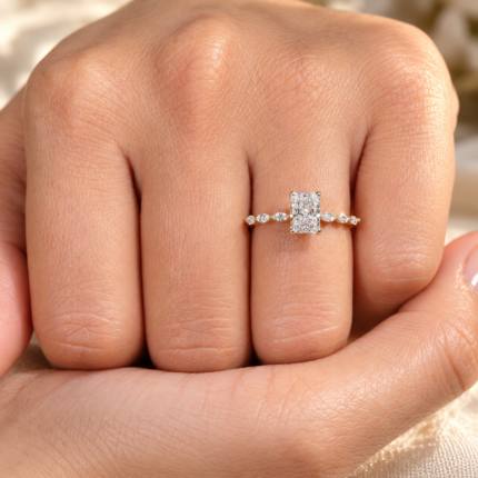 Radiant lab grown diamond ring with marquise accents, close view on a curled hand
