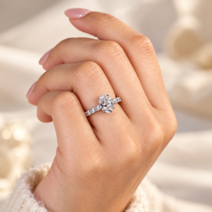 Oval lab diamond pavé ring worn on curled fingers