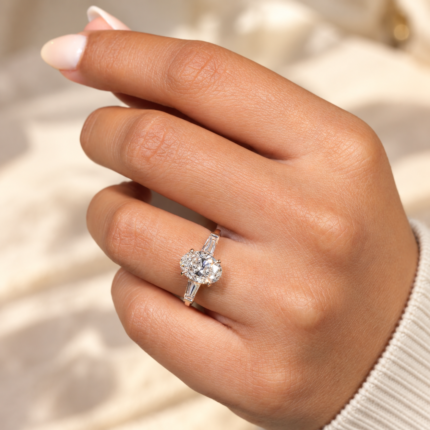 Sunlit hand view of oval diamond ring with tapered baguette accents
